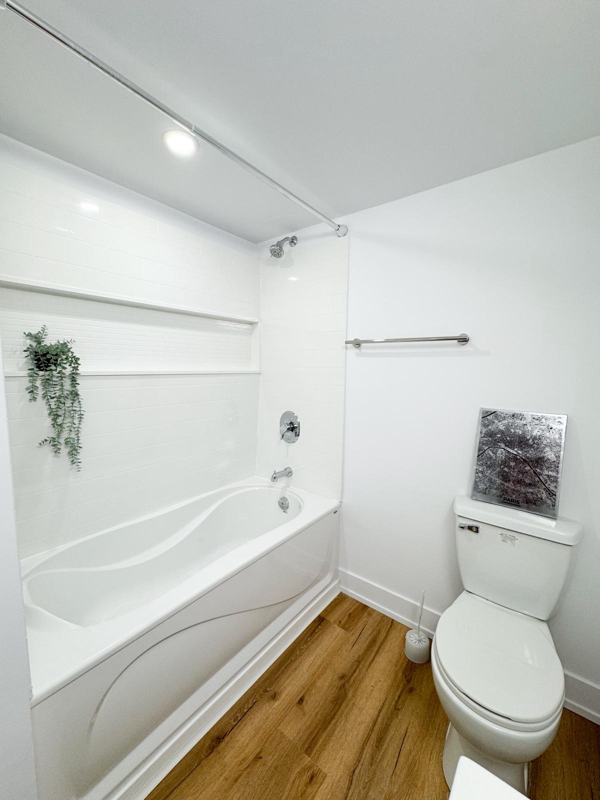 Finished basement bathroom with tub, shower, subway tile surround