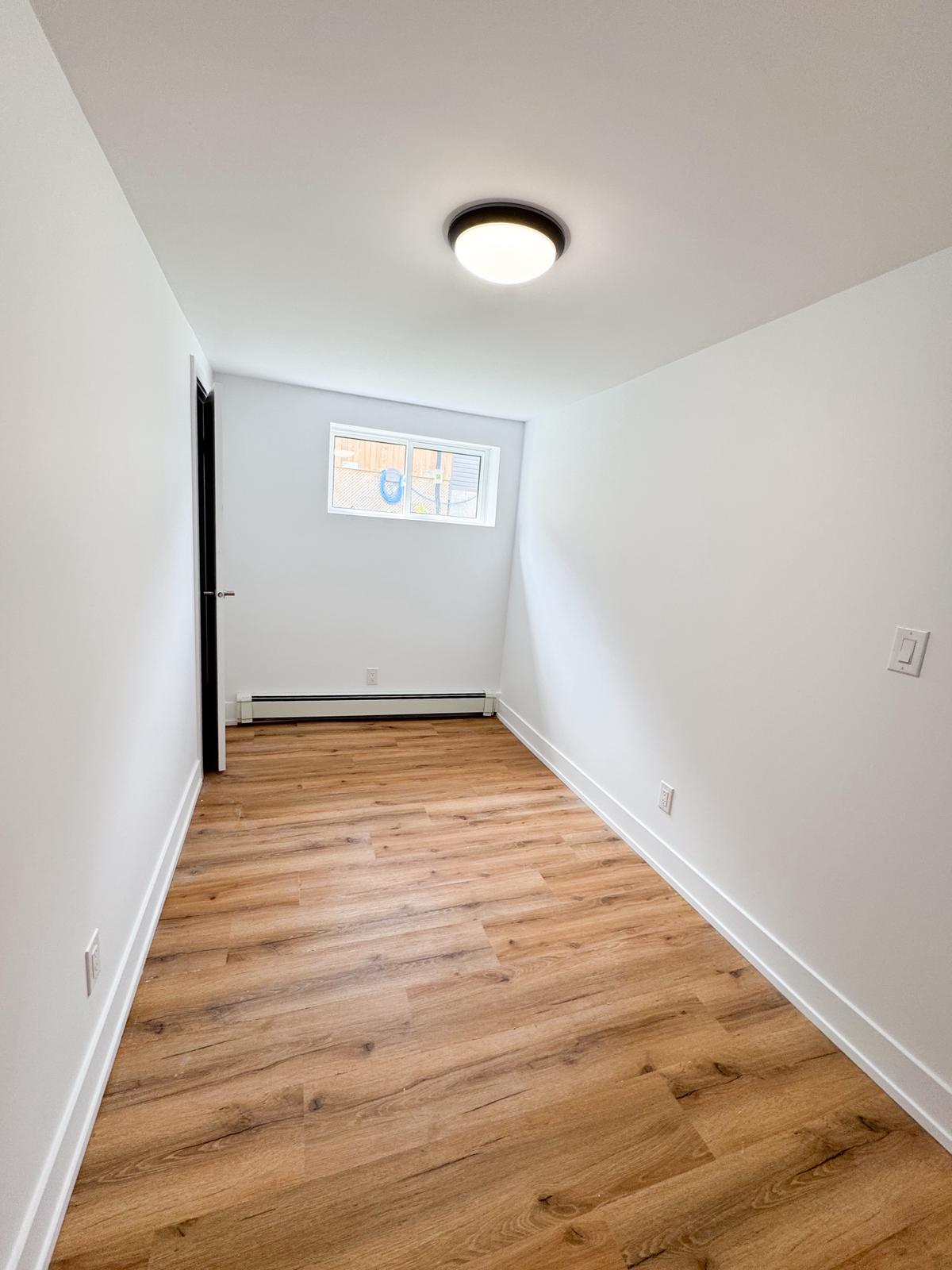 Second bedroom with egress window and modern light fixture